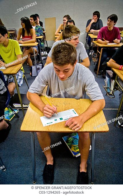 A Southern California high school student signs a Scantron card with a pencil before a multiple choice examination to allow electronic scoring