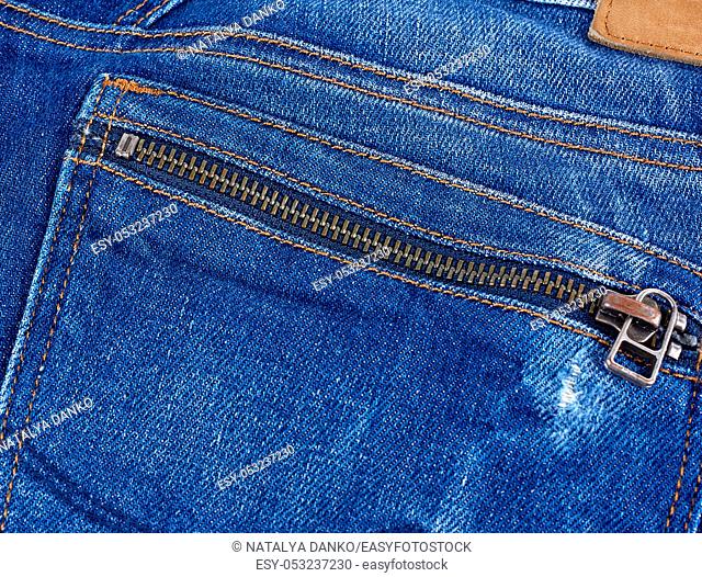 iron snake on the back pocket of blue jeans, full frame, close up