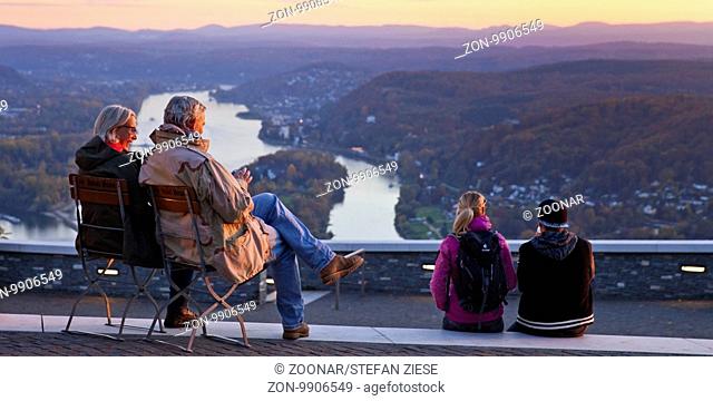 Zwei Paare sitzen bei Sonnenuntergang auf dem Drachenfels und sehen auf den Rhein, Siebengebirge, Koenigswinter, Nordrhein Westfalen, Deutschland, Europa