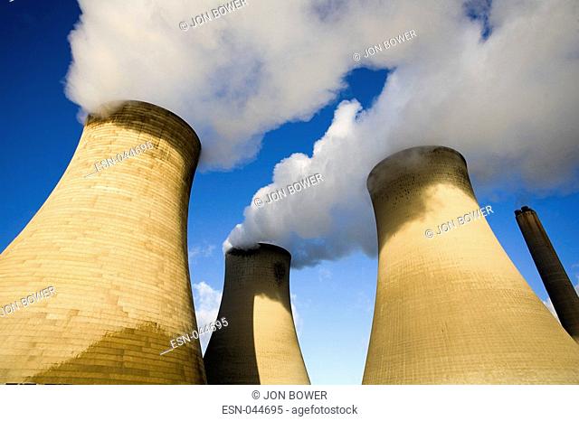 Cooling towers of Didcot Power Station on a cold winter morning, steam, bellowing out of towers, trees in foreground, burning, fossil fuels, power, electricity