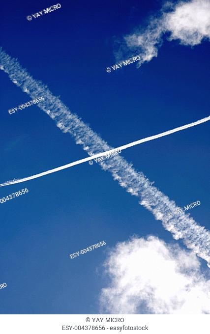 Passenger jet trails crossing in a blue sky