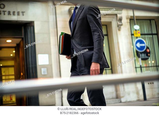 Closeup of unrecognizable businessman with portfolio walking down in the street in the city of London, England, UK