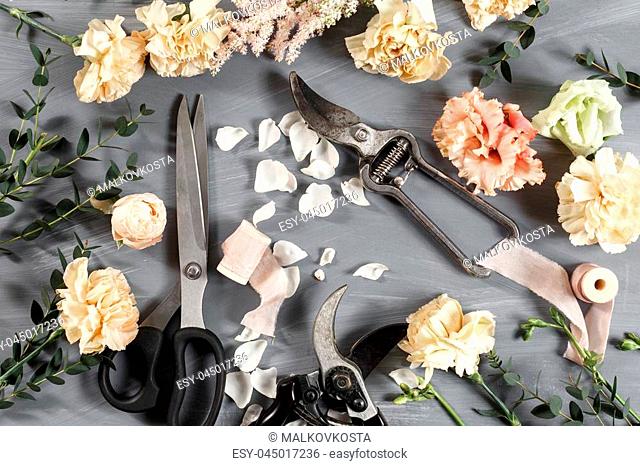 The florist desktop with working tools on white wooden background