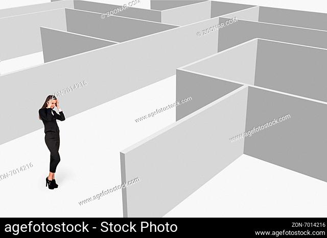 Beautiful businesswonan think against maze on grey background