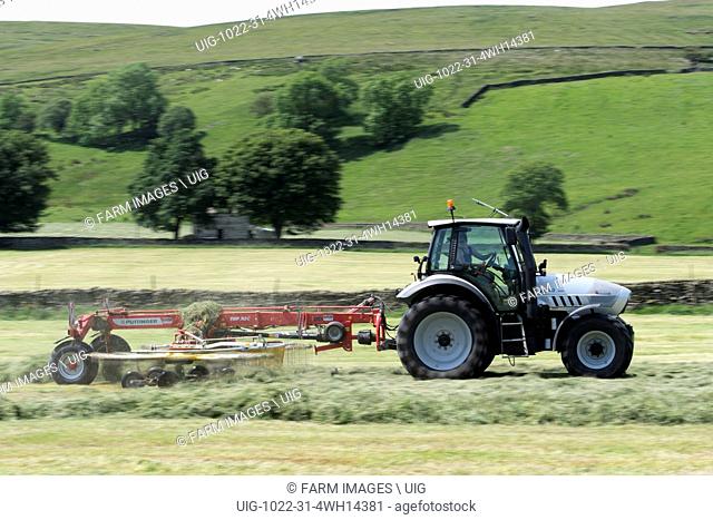 Rowing up grass for silage using a Pottinger rake pulled by a Hurlimann tractor