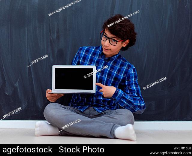 Arab teenager using laptop to work on homework and watch online education while staying at home cause coronavirus pandemic quarantine