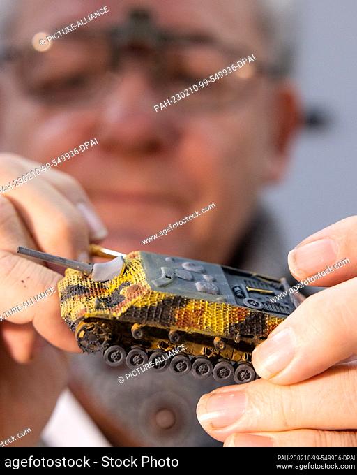 10 February 2023, Thuringia, Erfurt: Holger Weber paints a tank model with camouflage paint at the opening of the Thuringian model building fair ""Modell...