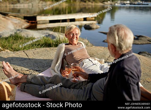 Smiling couple having picnic at lake