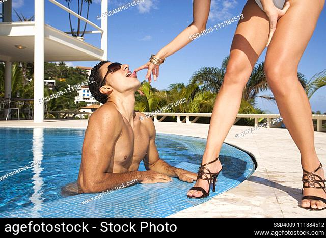 Hispanic couple relaxing in swimming pool