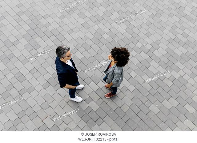 Top view of two colleagues talking on a square