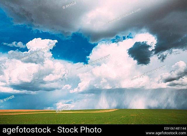 Countryside Rural Field Meadow Landscape In Sunny Rainy Spring Day. Scenic Sky With Rain Clouds On Horizon. Agricultural And Weather Forecast Concept