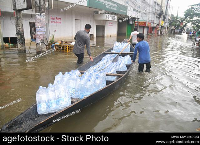 Sylhet, Bangladesh. 20th June 2022. People transporting bottled water in a raft during floods. The worst flooding in nearly 20 years has ravaged parts of...