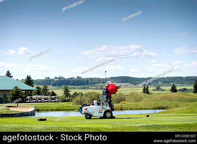 Disabled golfer using a specialized golf assistance motorized hydraulic wheelchair; Okotoks, Alberta, Canada