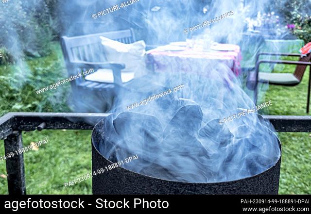 09 September 2023, Hamburg: Smoke saturated with soot and particulate matter rises from a charcoal grill. Photo: Markus Scholz/dpa/picture alliance/dpa | Markus...