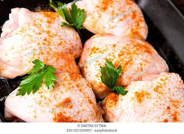 raw chicken with spice on frying pan