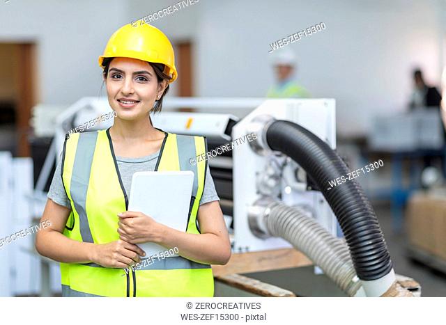 Portrait of smiling female technician with tablet