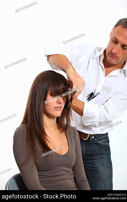 Hairdresser cutting woman's hair