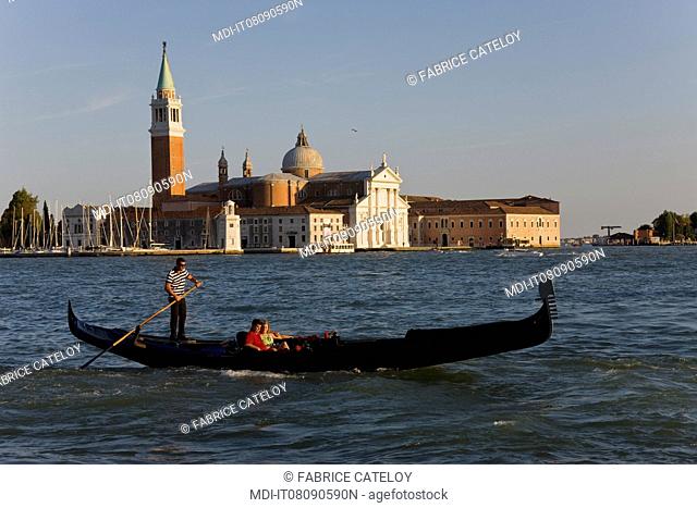 Gondola with tourists and in the background the San Giorgio Maggiore Island, the church and the campanile