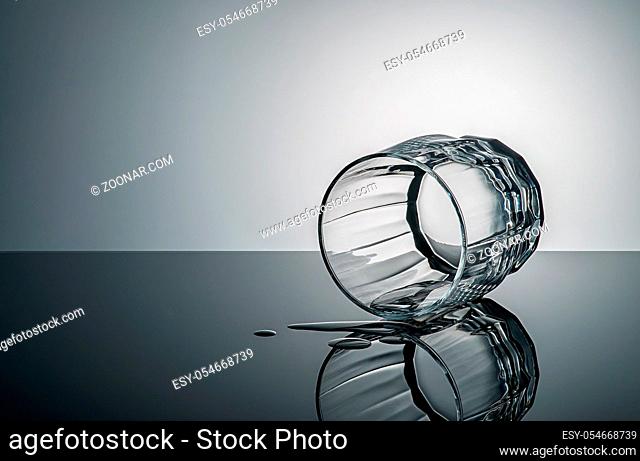 Lying glass with drops of water. Gradient background