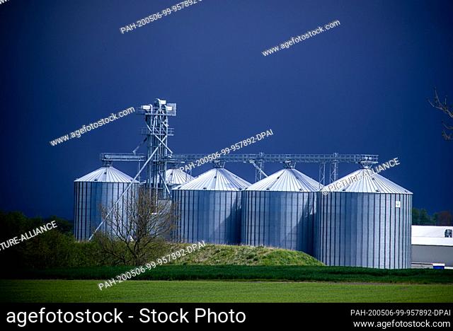 05 May 2020, Mecklenburg-Western Pomerania, Malchow (poel): Dark rain clouds are gathering behind a farm with large silos