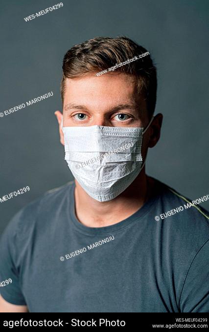 Young man wearing protective face mask in studio during pandemic