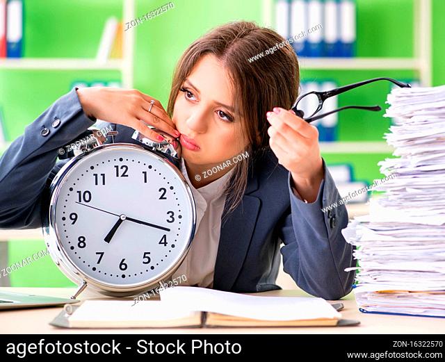 The young female employee very busy with ongoing paperwork in time m
