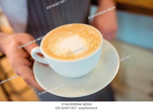 Close-up of coffee served by waitress at cafe