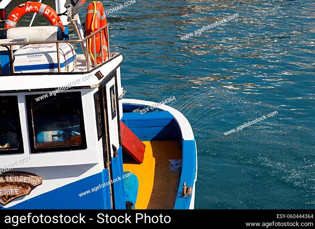 SAN JUAN, TENERIFE/SPAIN - FEBRUARY 25 : Fishing boat spraying water from stern in San Juan harbour on February 25, 2011