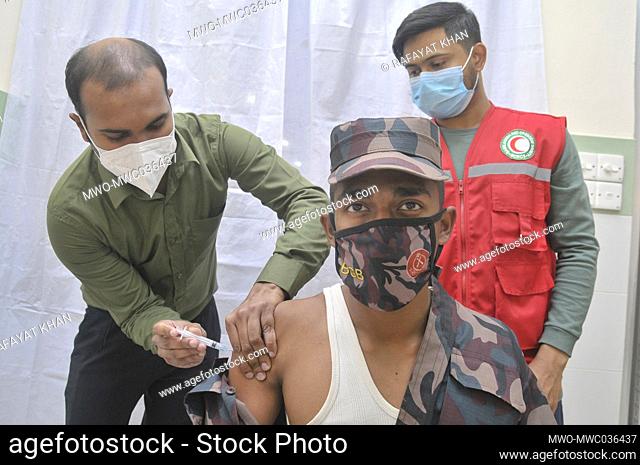 Health workers vaccinate a BGB (Border Guard Bangladesh) soldier during the first-stage coronavirus vaccination drive at MAG Osmani Medical College & Hospital-...