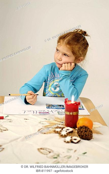 Little girl writing her Christmas wish list for Santa Claus