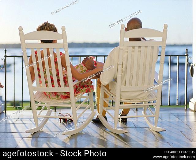 Rear view of couple sitting on deck