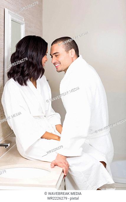 Smiling couple in bathrobe about to kiss
