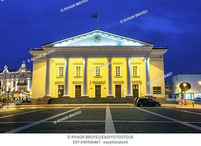 Vilnius, Lithuania. Main Facade Of Town Council In Evening Illumination, Administrative Building With Columns On Didzioji Street In Old Town Under Summer Blue...