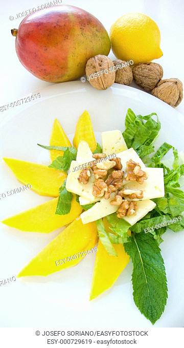 Salad with cheese, mango, lettuce, lemon and mint leaves