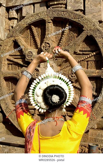 Odissi dancers strike pose re-enacts Indian myths such as Ramayana in front of iconic Sun Chariot in world heritage Sun temple complex in Konarak , Orissa