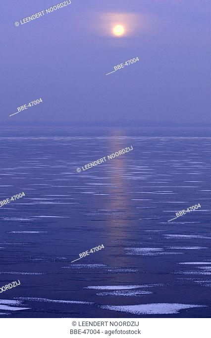 Moon above frozen lake