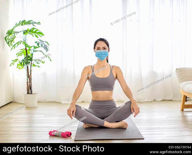Fitness woman streching Relaxing after training and wearing protectve face mask during Covid 19