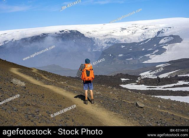 Hikers on trail through volcanic landscape, Myrdalsjökull glacier in the back, Fimmvörðuháls hiking trail, Þórsmörk Nature Reserve, Suðurland, Iceland, Europe