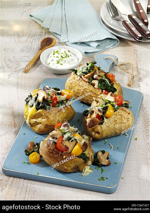 Baked potatoes filled with shiitake mushrooms, tomatoes, spinach and cheese