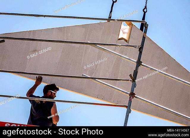 germany, bavaria, construction of a prefabricated wooden house, carpenter when transporting a gable wall with a construction crane