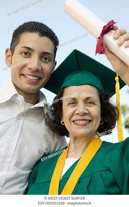 Senior Graduate hoisting diploma with son outside portrait