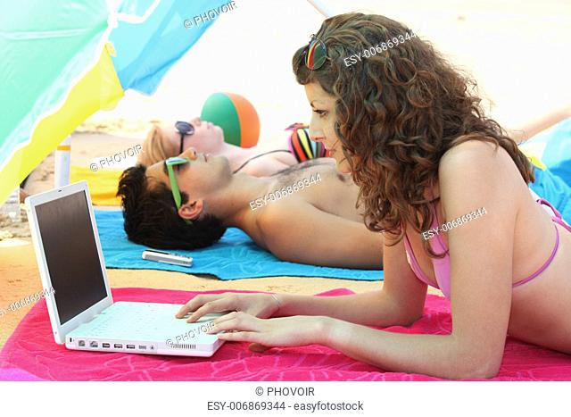 woman on the beach with laptop