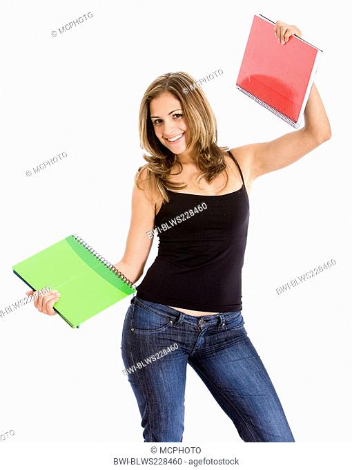 college student smiling and holding notebooks
