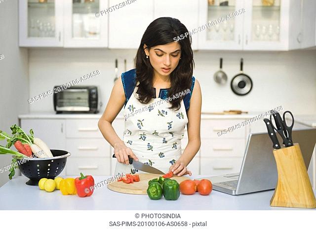 Woman chopping tomatoes in the kitchen