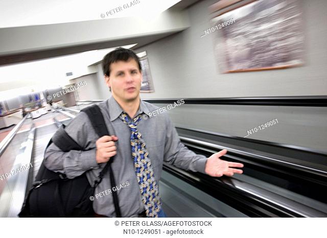 Young man standing on a moving walkway
