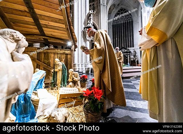 Archbishop Jozef De Kesel places a figure representing Jesus in a Nativity scene during the celebration of the Midnight mass on Christmas eve at the...