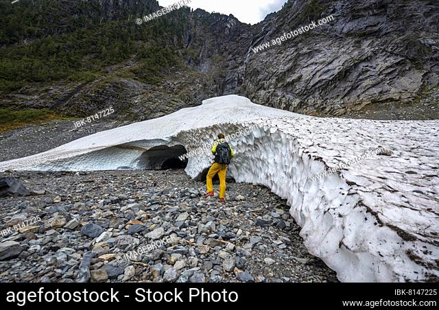 Hikers at the entrance of an ice cave of a glacier, Big Four Ice Caves, Okanogan-Wenatchee National Forest, Washington, USA, North America