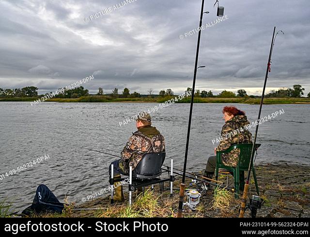 14 October 2023, Brandenburg, Brieskow-Finkenheerd: Anglers sit on a groyne at the project day ""Fishing for Science on the Oder""
