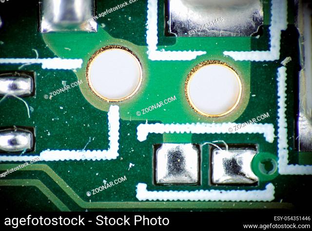 macro photo of the two holes and solder on electronic circuit board pcb