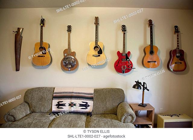 Collection of guitars hanging on wall